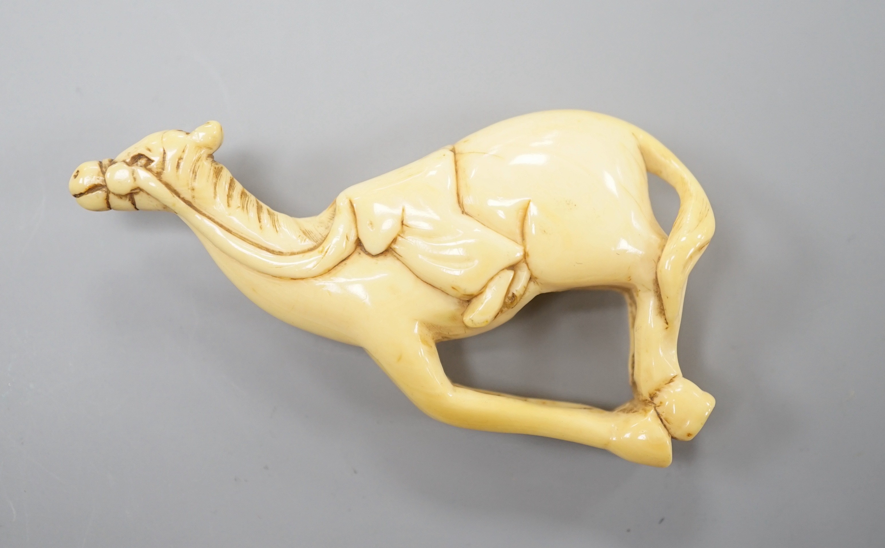 A Japanese ivory netsuke of a horse, late 18th/early 19th century, lacking rider and re-shaped at the saddle, 6cm
